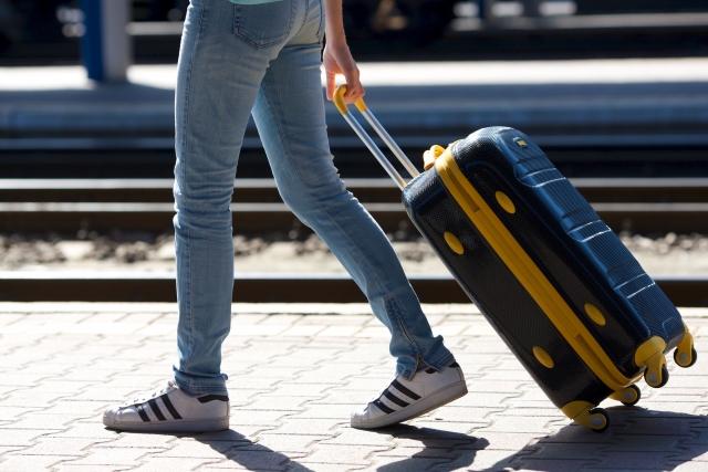 Arriving in Japan: From Airport to Hotel Traveller wheeling a suitcase along a station platform in Japan