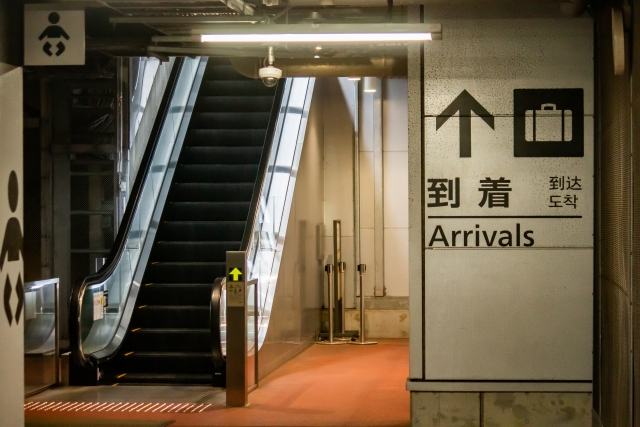 Arriving in Japan: From Airport to Hotel Arrivals hall signage and escalator inside a Japanese airport terminal