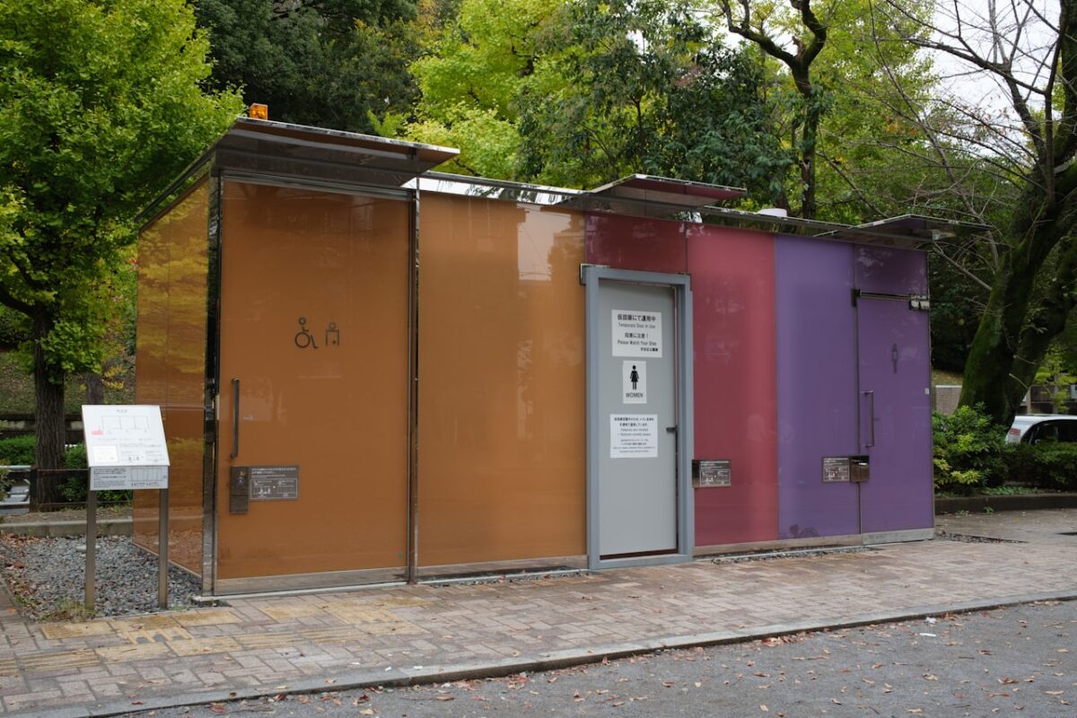 A colourful public restroom building with trees in Japan