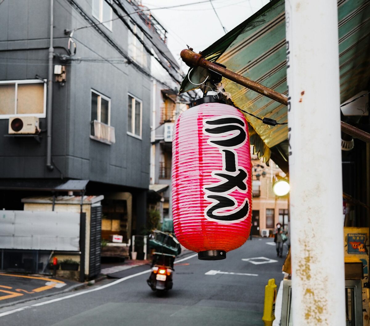 Essential Japanese Phrases for Your Japan Trip — and When You Actually Need Them A red paper lantern hanging in a Japanese street