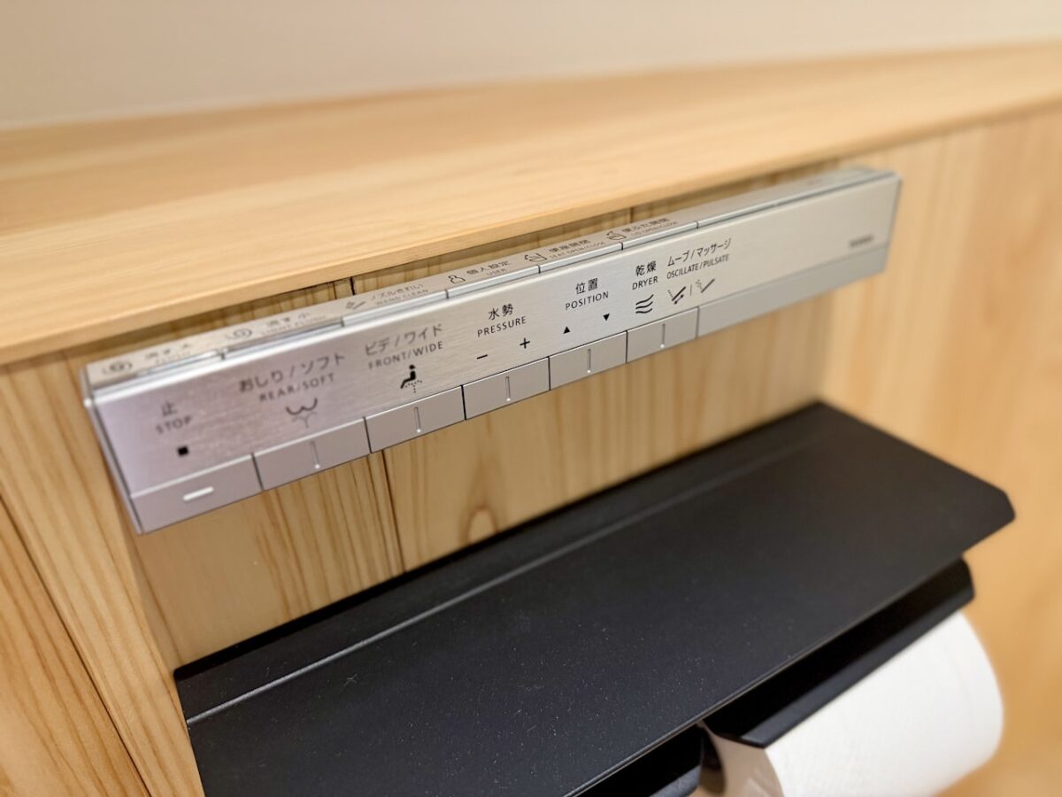Close-up of a modern Japanese toilet control panel with buttons