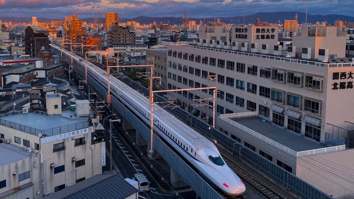 Getting Around Japan: A First-Timer's Guide to Trains, IC Cards and City Transport A train travelling through a city next to tall buildings in Japan