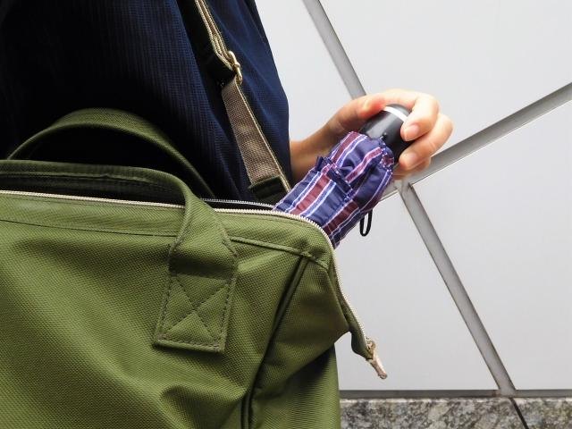 How to Enjoy a Rainy Day in Japan: Ideas for Travellers A folding umbrella being taken from a shoulder bag