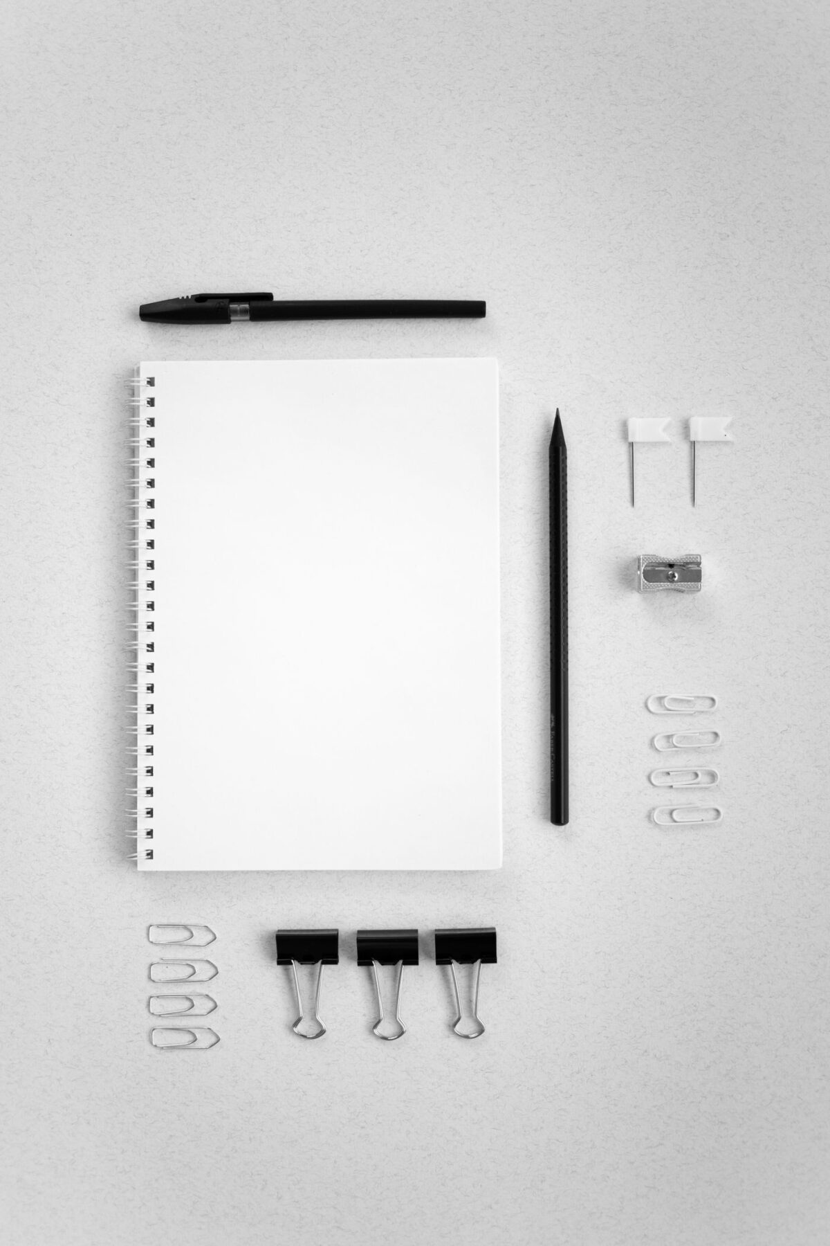 Flat lay of notebook, pencil and stationery on a white surface