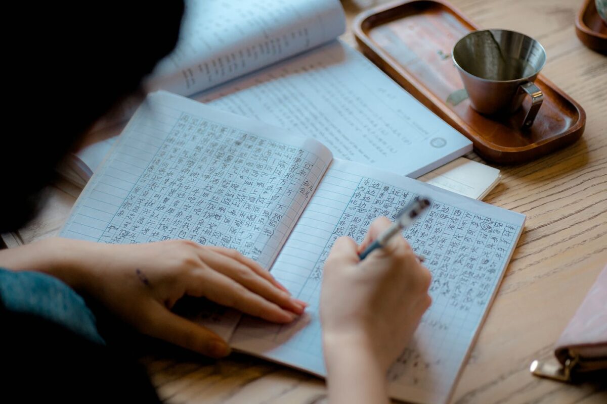 Hand writing Japanese characters in a notebook